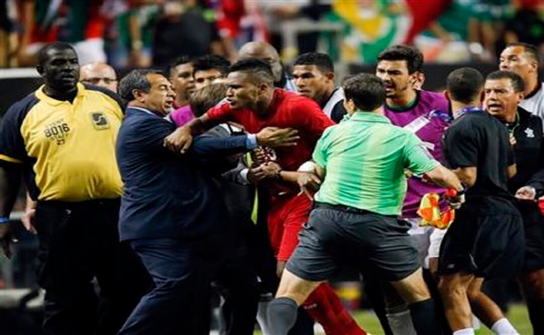 Panama's Erick Davis (15) is restrained as tempers flare during the second half of a CONCACAF Gold Cup soccer semifinal between Panama and Mexico. (Photo: AP)