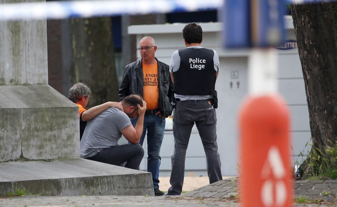 Agentes de policía belga consuelan a un transeúnte en el lugar de un tiroteo en Lieja, Bélgica. (FOTO: EFE)