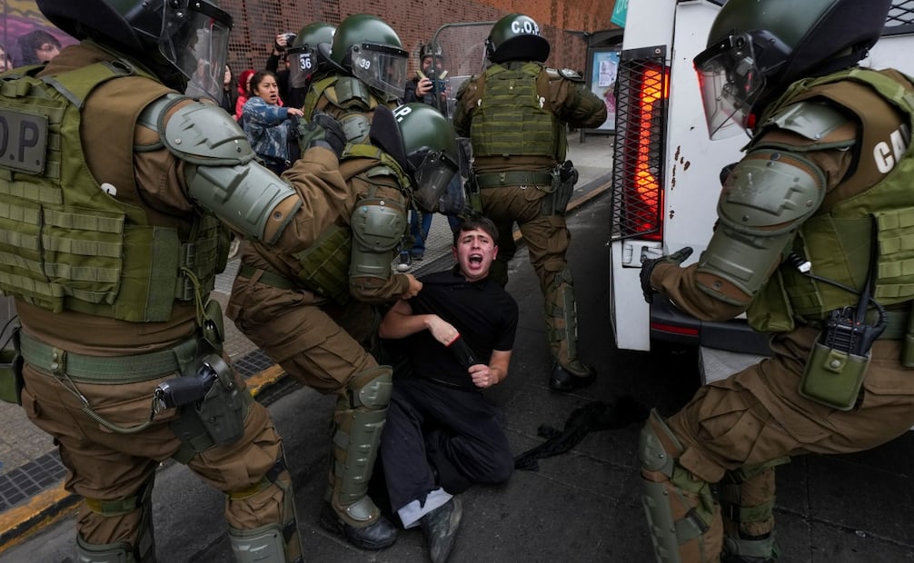 Un estudiante es detenido durante la marcha que dejó 35 arrestos y denuncias por represión en Santiago. Foto: AP