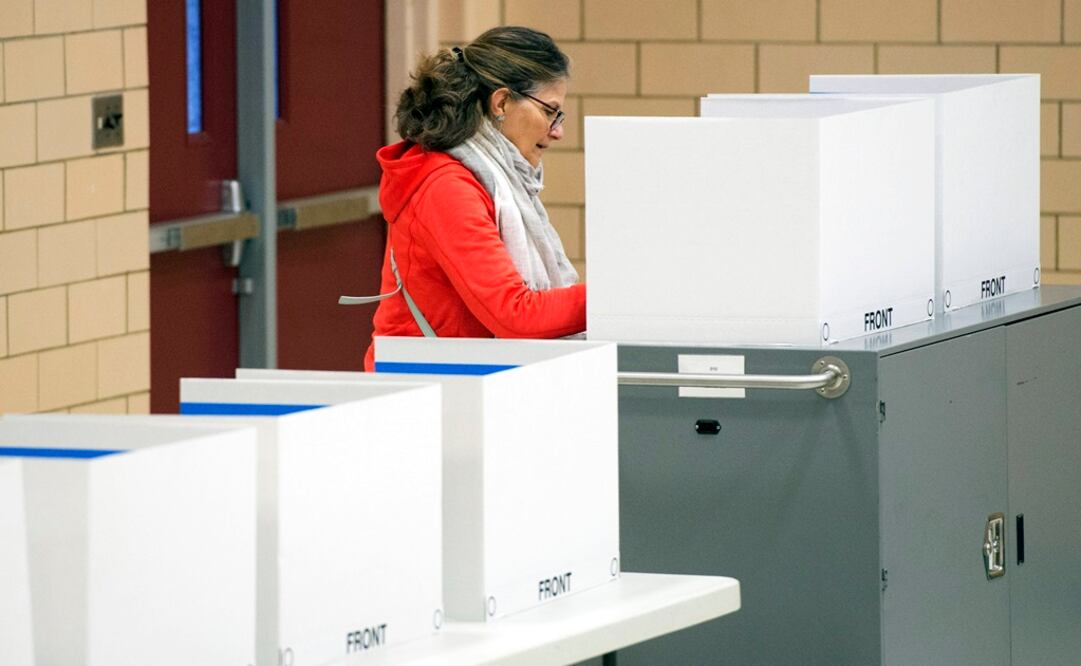 Una mujer vota en las primarias de Virginia en un centro electoral instalado en el gimnasio de un colegio en Arlington (Foto: EFE)