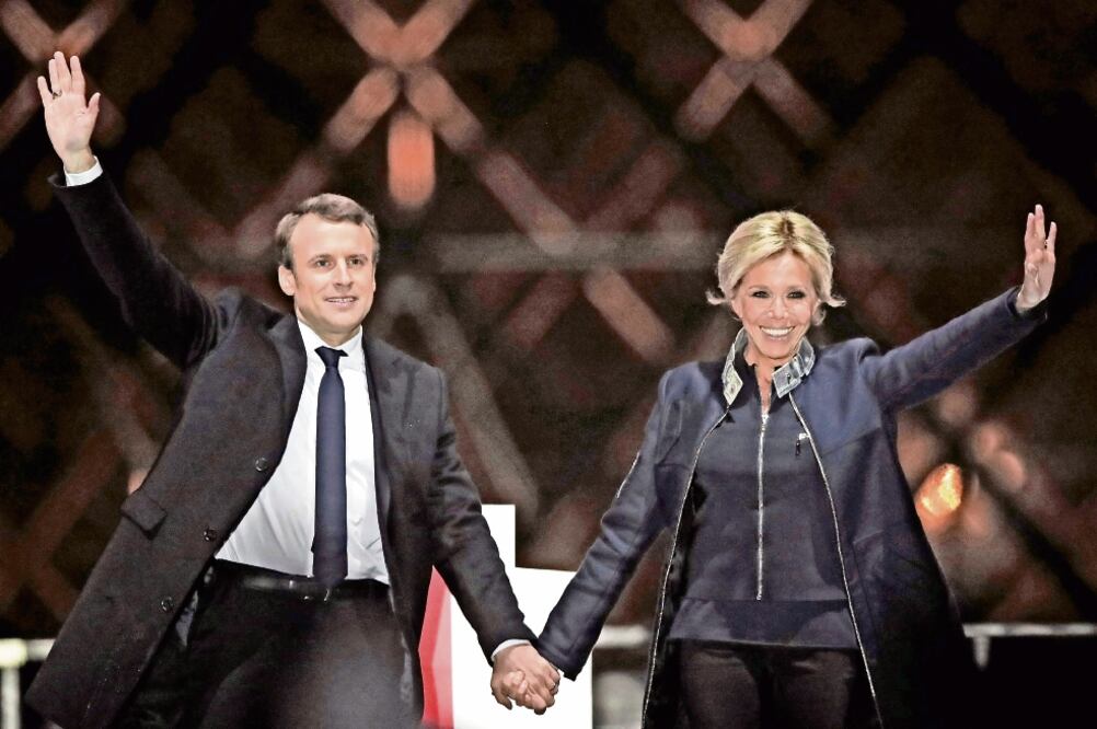 El presidente electo de Francia, Emmanuel Macron, y su esposa Brigitte Trogneux al celebrar su victoria en la plaza del Museo del Louvre tras las elecciones del pasado 7 de mayo (CHRISTIAN HARTMANN. REUTERS)
