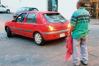 "Franeleros" cobran hasta $150 por auto