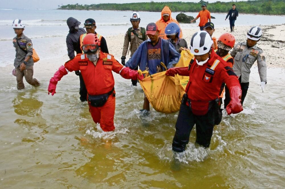 Trabajadores de rescate llevan una bolsa con los restos de una víctima del tsunami que golpeó el sábado pasado en Tanjung Lesung, en Pandeglang, provincia de Banten, Indonesia (MUHAMMAD ADIMAJA. REUTERS)
