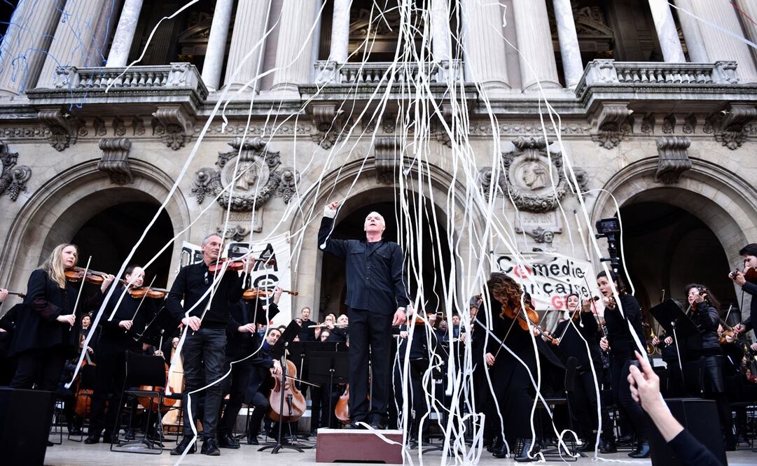 El director de la Ópera Nacional de París, Michel Dietlin, dirige a los músicos de su orquesta en el exterior del Palacio Garnier en París. Foto: EFE/ Julien De Rosa