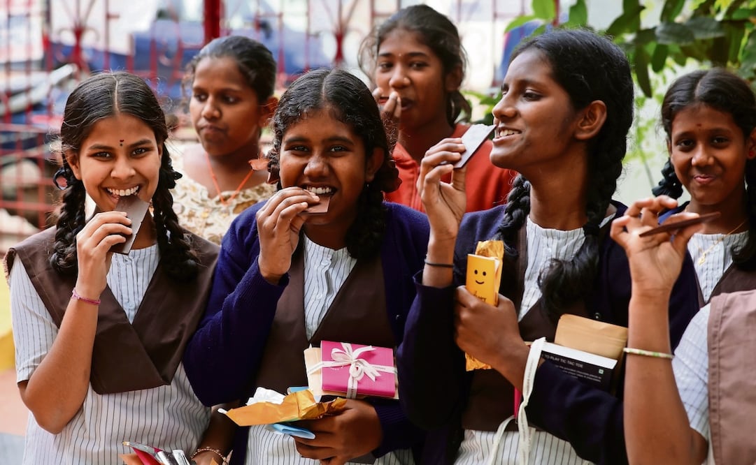 Chicas en Bangalore, India, disfrutaron de una pieza de chocolate durante el Día Mundial de esta golosina, el pasado 7 de julio. Foto: EFE