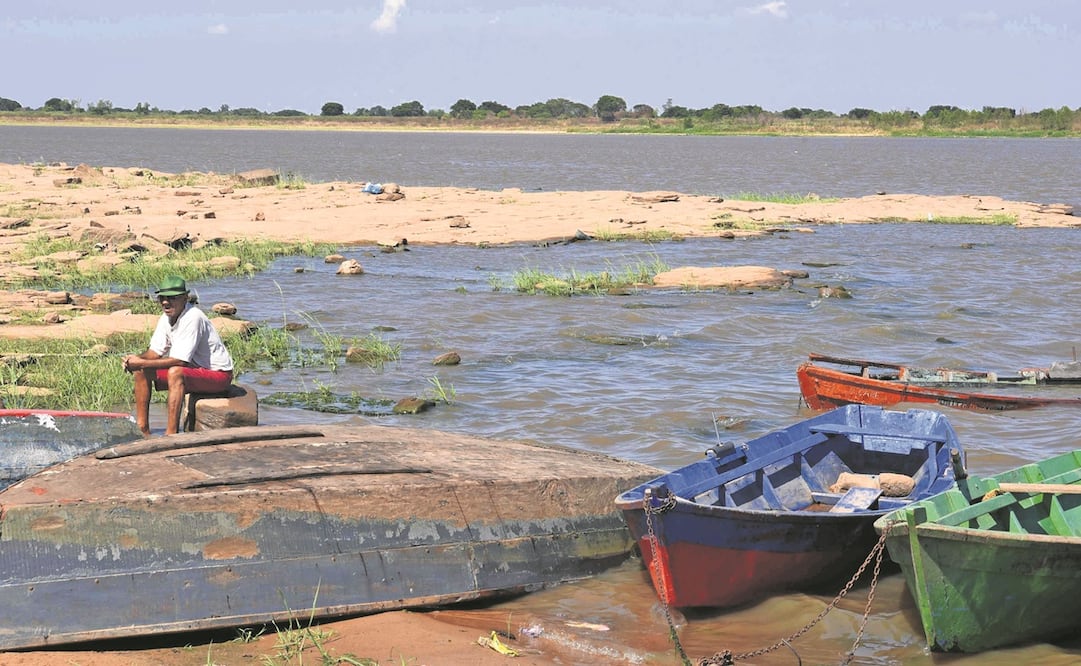Un pescador espera en la orilla de un río en Paraguay, afectado por una sequía que ha impactado el paso del sector naviero. Foto: Norberto Duarte/ AFP