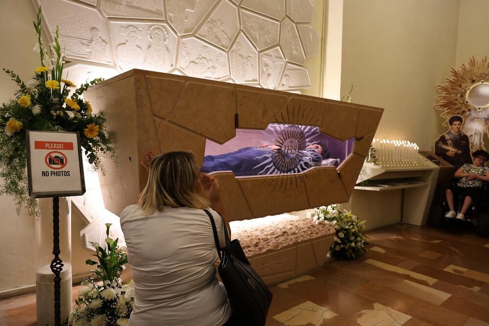 Un fiel reza ante el féretro de San Carlo Acutis, en el Santuario de la Renunciación, en Asís. FOTO: EFE