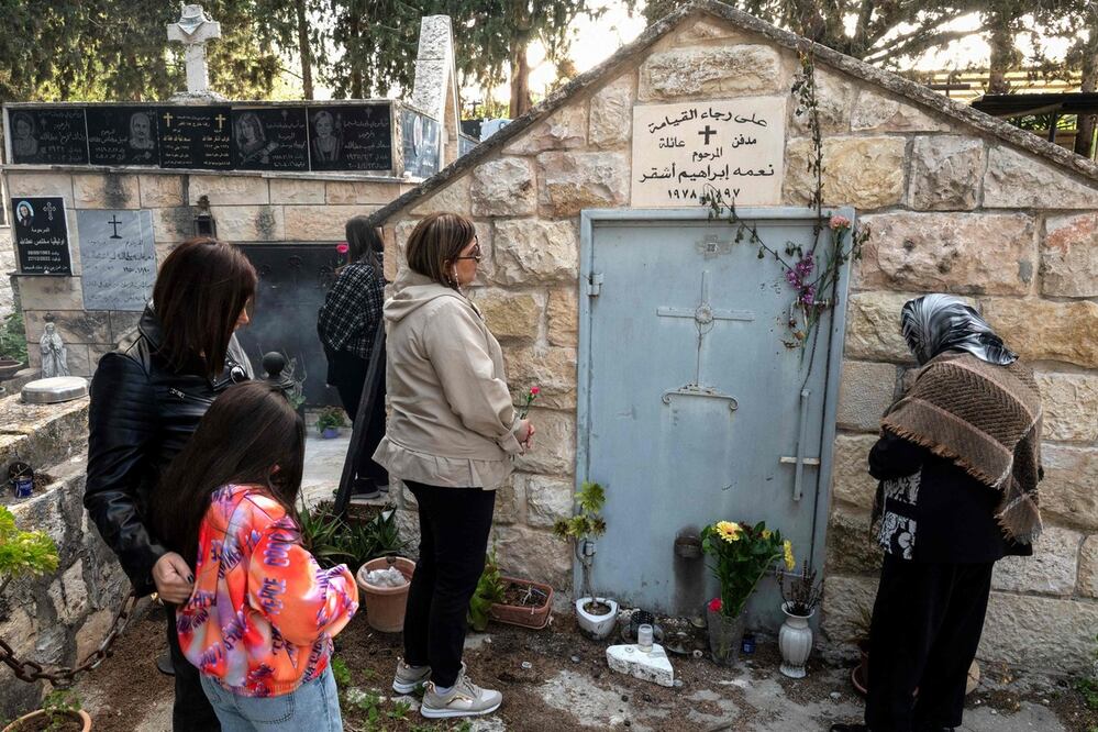 Los creyentes cristianos visitan una tumba en el cementerio de la aldea palestina de Iqrit. Foto: AFP