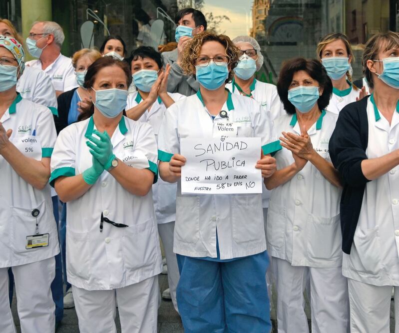 Exigencia. Empleadas de la salud demandan mejores condiciones salariales, afuera de una clínica en Barcelona. LLUIS GENE. AFP