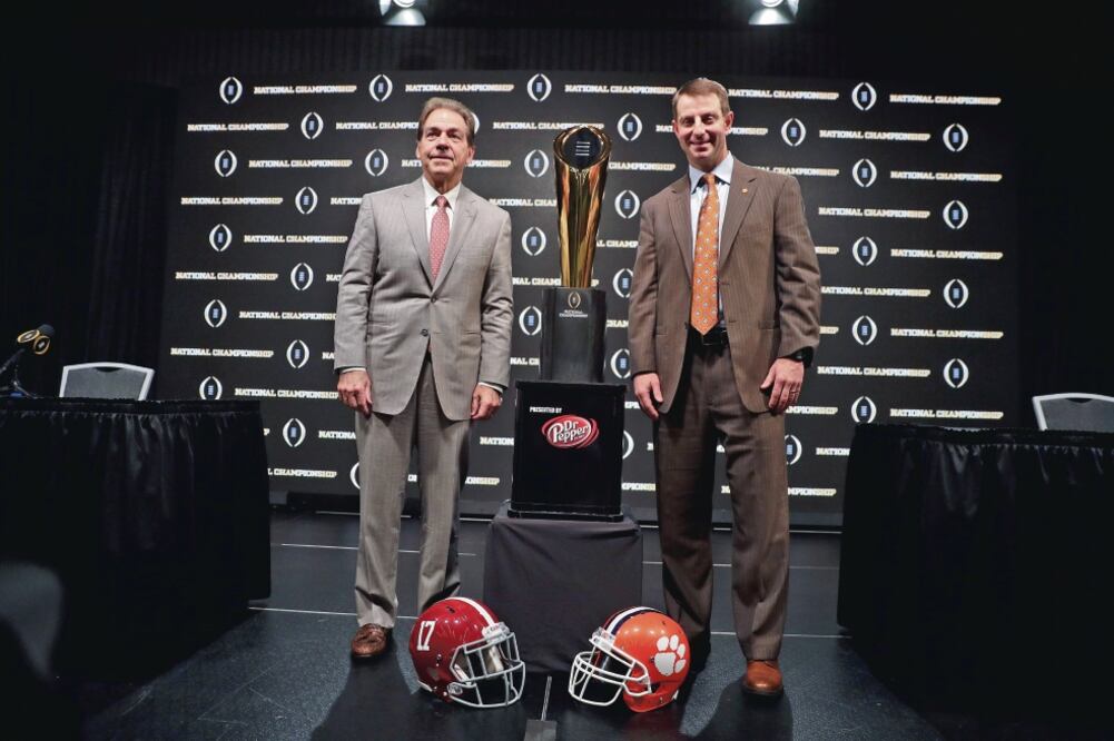 Junto al trofeo, los coaches Nick Saban, de Alabama, y Dabo Swinney, de Clemson (DAVID J. PHILLIP. AP)