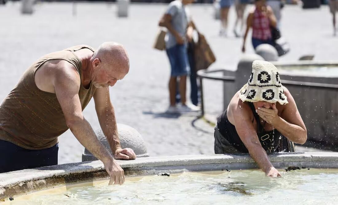 Un grupo de personas se refresca en una fuente en un día caluroso en la Plaza de España de Roma, bajo la Escalinata Española. FOTO: AP