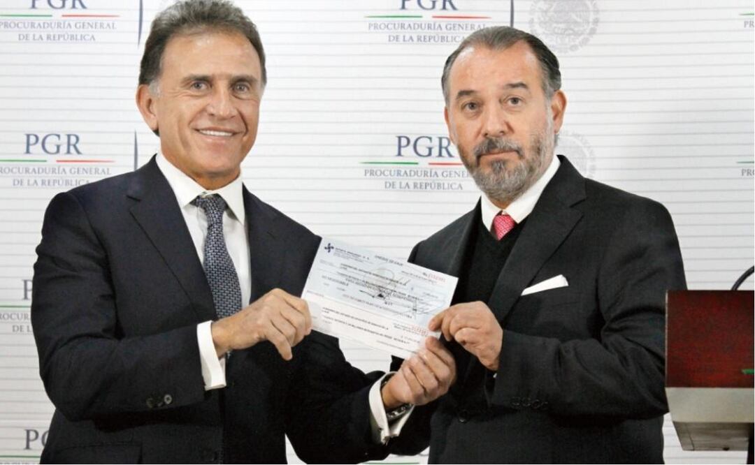 The head of the Attorney's General Office seen here handing Veracruz's governor a check for 172 million pesos (7.8 million dollars) during a televised ceremony. (Photo: IRVIN OLIVARES / EL UNIVERSAL)