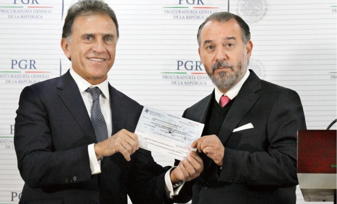 The head of the Attorney's General Office seen here handing Veracruz's governor a check for 172 million pesos (7.8 million dollars) during a televised ceremony. (Photo: IRVIN OLIVARES / EL UNIVERSAL)