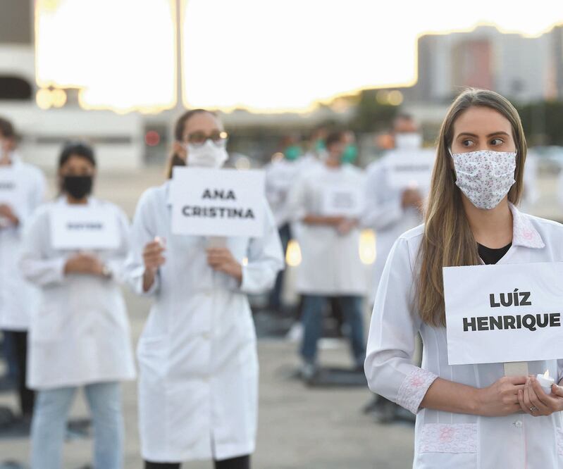 Empleados de la salud brasileños honraron ayer a sus compañeros que han fallecido por el coronavirus, en Brasilia. La OPS dijo que ve con “preocupación” la propagación de la enfermedad en la nación, que registró 881 decesos en un día. Foto: AFP