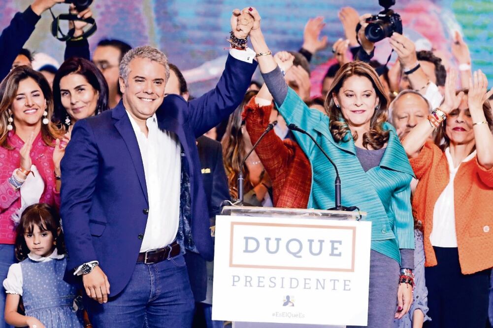 El presidente electo de Colombia, Iván Duque (izq.), y Marta Lucía Ramírez, quien será su vicepresidenta (der.), saludan desde su sede de campaña en Bogotá tras los resultados de la elección de ayer. Foto: MAURICIO DUEÑAS. EFE