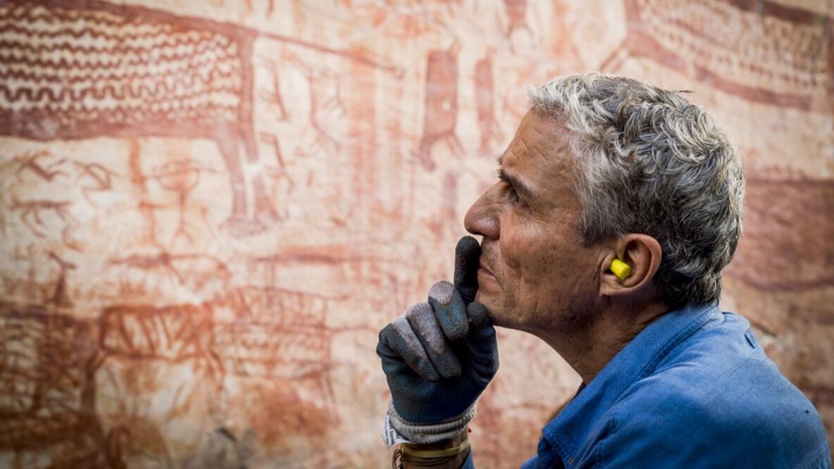 Carlos Castaño observando varios de los miles de dibujos de arte rupestre en Chiribiquete. Foto: JotaArango/Fundacion Herencia