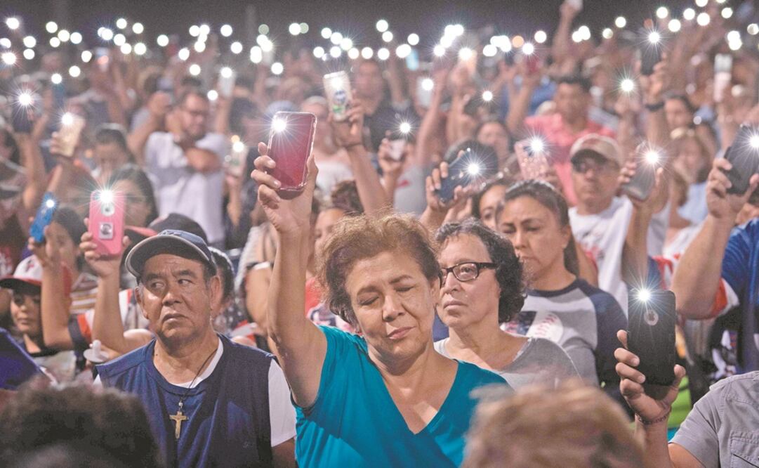 La noche del domingo decenas de personas se reunieron en el sitio donde murieron 22 personas el sábado pasado, en El Paso, Texas, luego de que un joven de 21 años disparó contra los visitantes de un centro comercial. Foto: MARK RALSTON. AFP