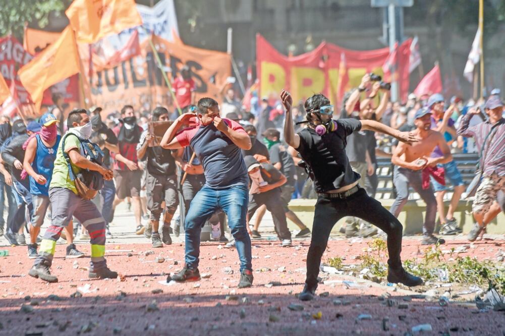 Manifestantes lanzaron piedras a la policía durante un enfrentamiento durante las protestas contra la propuesta de reforma a las pensiones, en Buenos Aires (EITAN ABRAMOVICH. AFP)