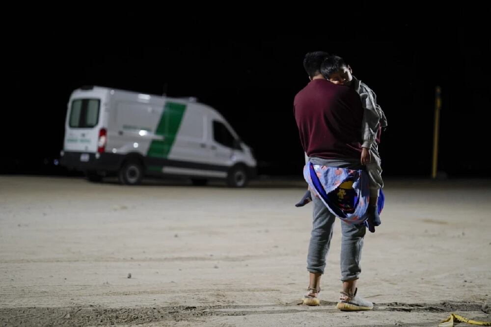 Un hombre colombiano carga a su hijo mientras espera a solicitar asilo después de cruzar la frontera desde México, el martes 11 de julio de 2023, cerca de Yuma, Arizona. Foto: AP