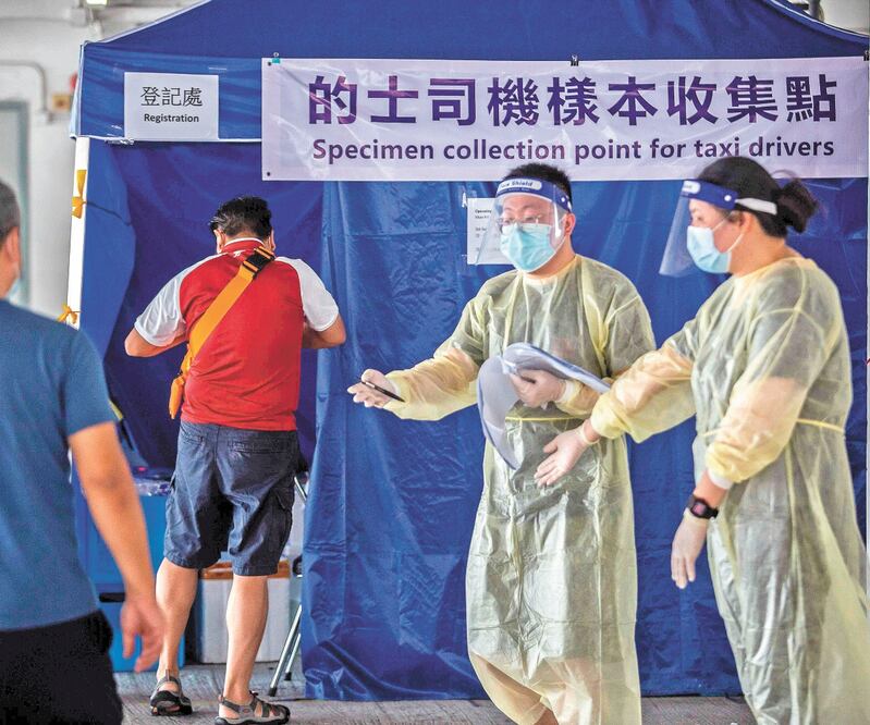 Habitantes de Hong Kong acudieron ayer a realizarse una prueba de Covid-19 en una estación improvisada en un estacionamiento. Foto: ISAAC LAWRENCE. AFP