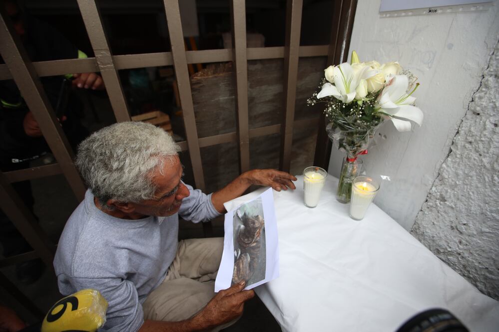 José Luis Capistran llora ante un altar colocado por vecinos a Zeus su perro que ayer fue ultimado al defenderlo. Foto: Francisco Rodríguez.