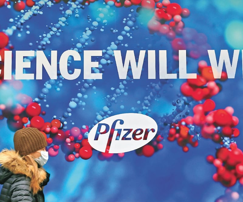 Una persona, con cubrebocas, pasa junto a la sede de la farmacéutica Pfizer en Nueva York. ANGELA WEISS. AFP