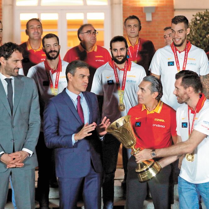 El presidente del gobierno, Pedro Sánchez (al frente segundo de izq. a der.) recibe la copa de manos del capitán de la selección española de baloncesto Rudy Fernández, acompañados por integrantes del equipo. EMILIO NARANJO. EFE