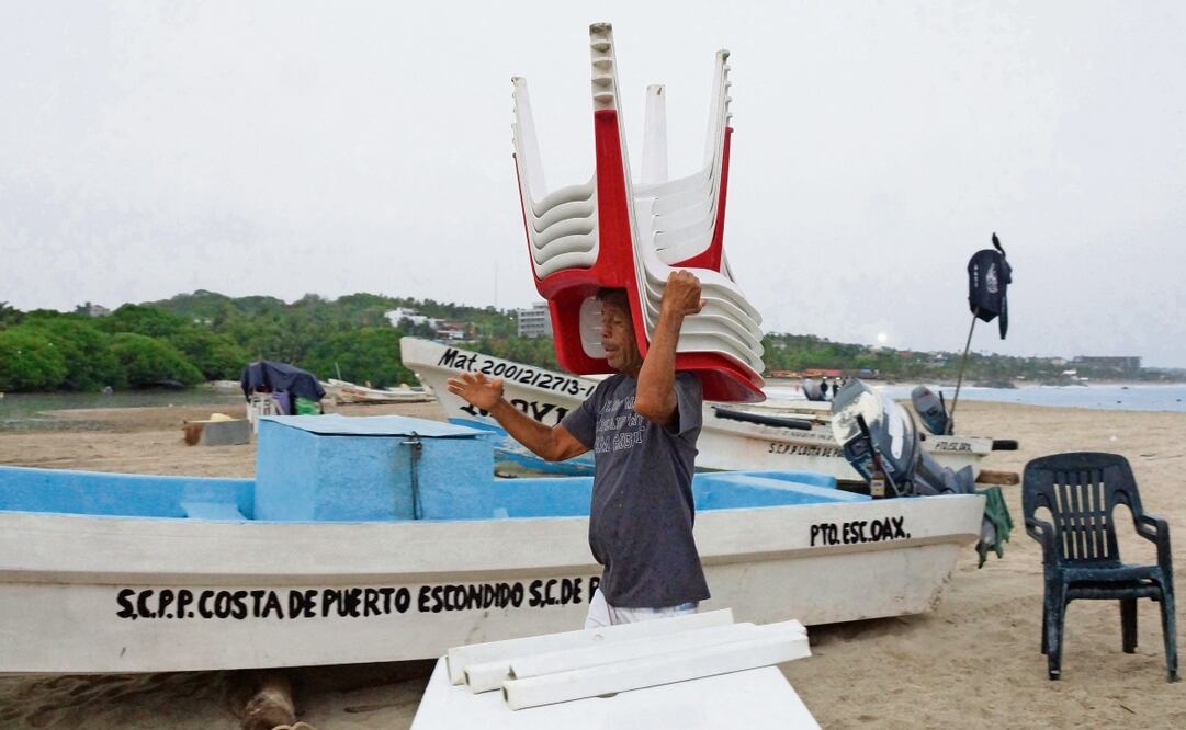 Pescadores amarraron en tierra sus lanchas para prevenir el impacto de la entrada del huracán Erick a las costas de Oaxaca. Foto: Edwin Hernández / EL UNIVERSAL