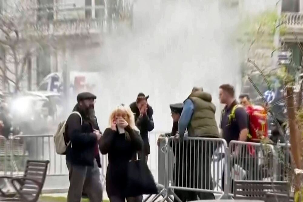 Los transeúntes reaccionan después de presenciar cómo apagaban a un hombre que se prendió fuego, en un parque frente al tribunal penal de Manhattan, en Nueva York. Foto: AP