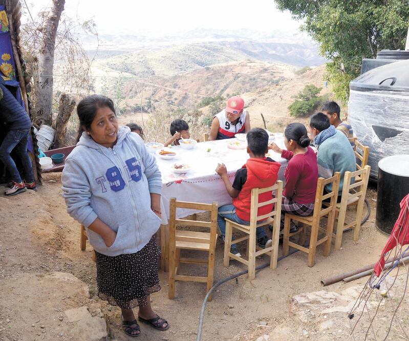 En familia, habitantes de Santos Reyes Yucuná comieron pozole de pollo y caldo de res criolla mientras esperaban el arribo del Presidente. Foto: EDWIN HERNÁNDEZ. EL UNIVERSAL