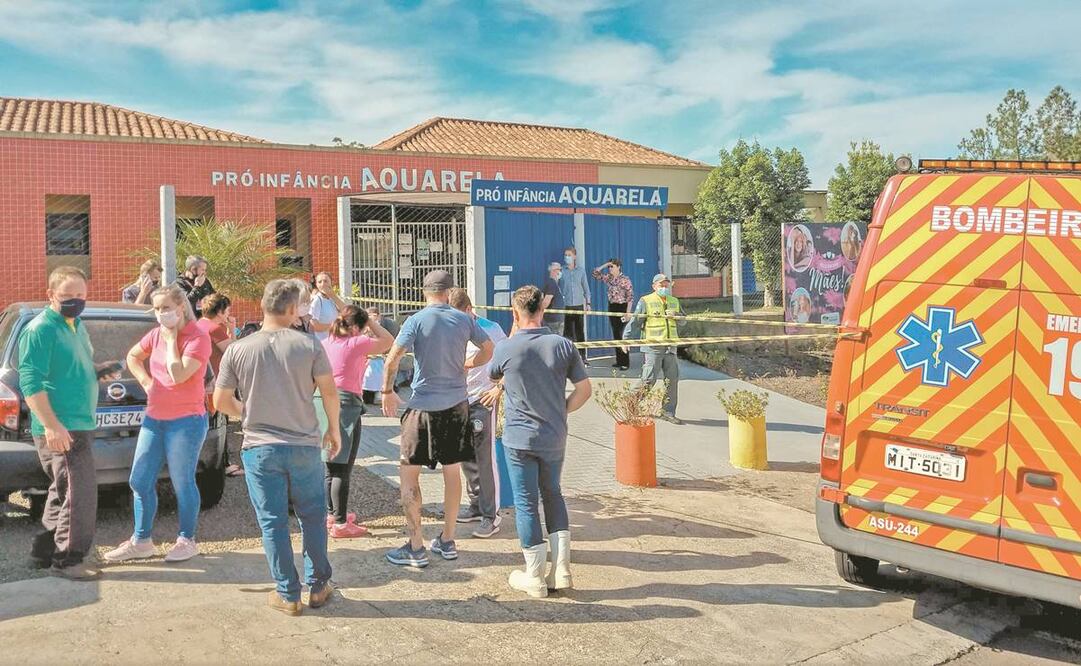 Personas y autoridades locales en los alrededores de la Guardería Aquarela, luego de que un joven de 18 años armado con un cuchillo matara a tres niños y dos empleadas, en Saudades, Santa Catarina. Foto: Jocimar Barbosa/ AFP. 