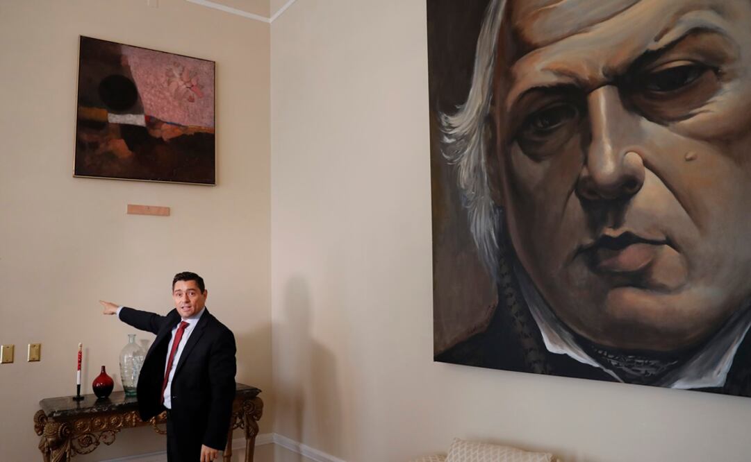 Carlos Vecchio, político exiliado que Estados Unidos reconoce como embajador de Venezuela, señala una sección vacía de una pared donde una vez colgó una obra de arte. AP Foto/Pablo Martinez Monsivais Foto: 