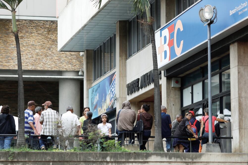 Gente hace fila para retirar dinero de un cajero automático en Caracas, Venezuela. El gobierno sostuvo ayer una reunión con tenedores de bonos para renegociar su deuda externa, pero no hubo resultados (MARCO BELLO. REUTERS)