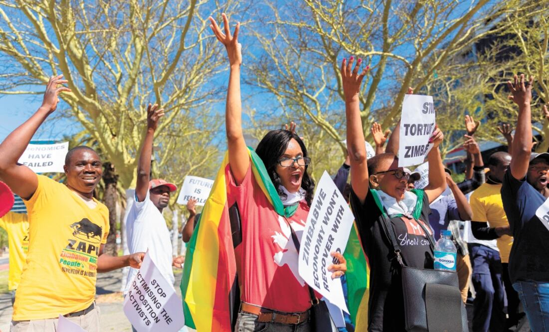 Ciudadanos de Zimbabue celebraron en Sudáfrica la muerte del expresidente Robert Mugabe. Foto/NIC BOTHMA. EFE