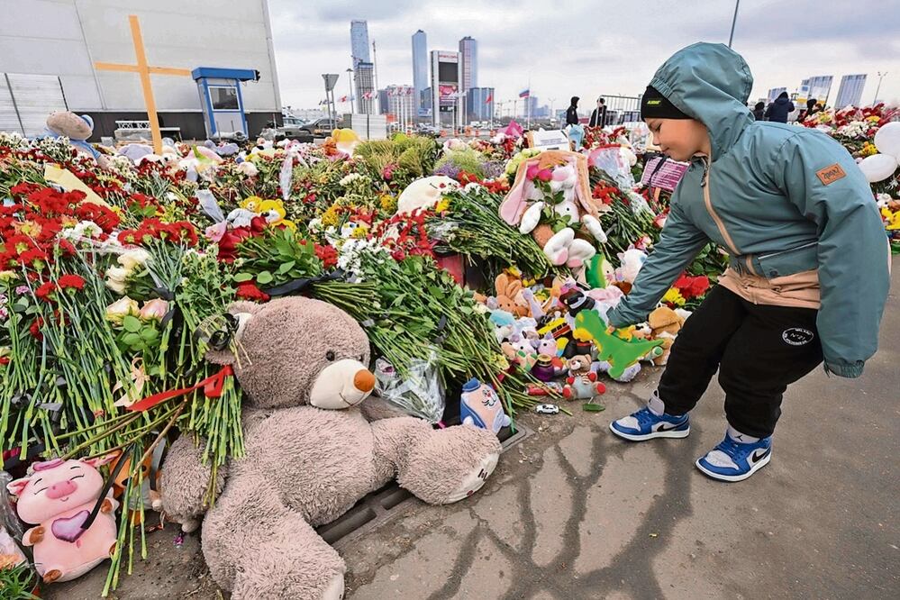 Un niño deposita flores en un memorial frente al ayuntamiento de Crocus en el suburbio de Krasnogorsk. Foto: de Natalia Kolesnikova. AFP