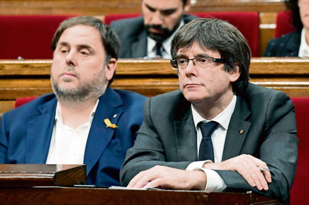 Oriol Junqueras, vicepresidente catalán, y Carles Puigdemont, mandatario de la comunidad, ayer en el Parlamento regional, en Barcelona (LLUIS GENE. AFP)