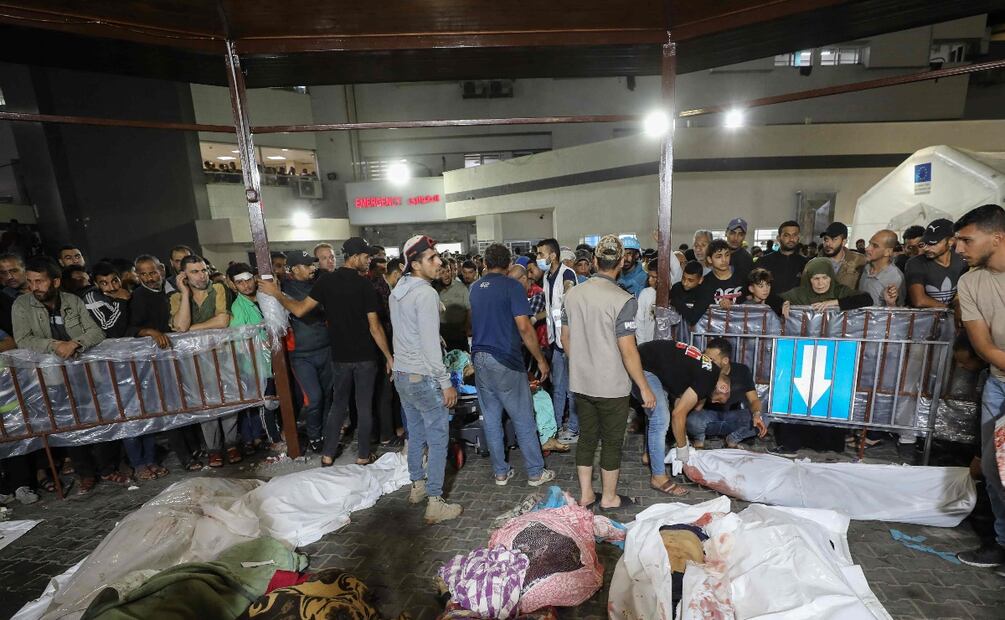 La gente se reúne alrededor de los cuerpos de palestinos muertos en los ataques aéreos israelíes contra el hospital Ahli Arab en el centro de Gaza después de que fueron transportados al hospital Al-Shifa. Foto: AFP