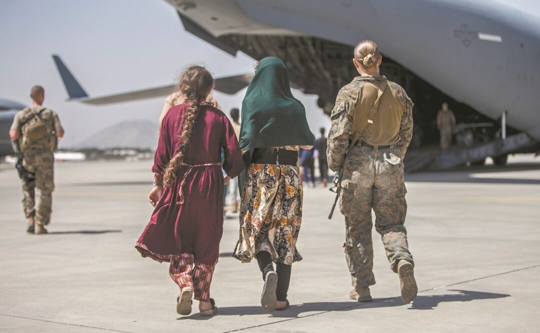 Una marine estadounidense, con una familia durante las evacuaciones en el Aeropuerto Internacional Hamid Karzai, en Kabul. Foto: AP
