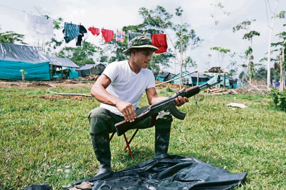 Un rebelde de las Fuerzas Armadas Revolucionarias de Colombia (FARC) limpia sus rifles, ayer, en el campamento en La Carmelita, en el suroeste de Putumayo (FERNANDO VERGARA. AP)