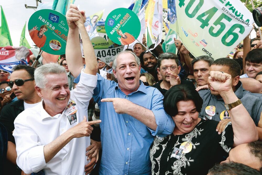 El candidato a la presidencia de Brasil por el Partido Democrático Trabalhista (PDT), Ciro Gomes (centro), junto al político Rodrigo Rollemberg (izquierda), participan en un acto de campaña, en Brasilia. (JOÉDSON ALVES. EFE)