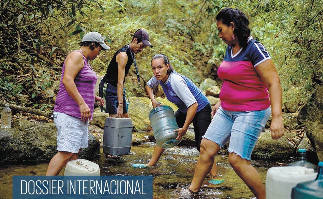 Venezolanos llenan garrafones de la montaña Waraira Repano, conocida como el parque nacional El Ávila, en Caracas. FEDERICO PARRA. AFP