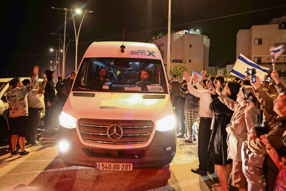 La gente aplaude mientras un vehículo que transporta rehenes liberados por Hamas se dirige hacia una base militar en Ofakim, en el sur de Israel. Foto: AFP