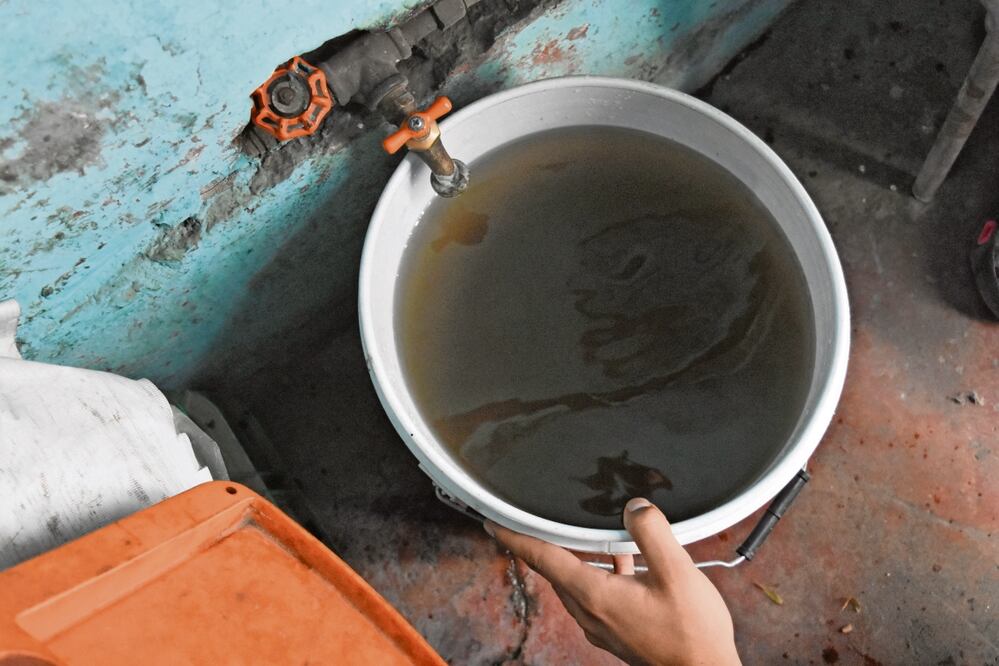 Vecinos de Ampliación 7 de Julio demostraron que el agua sale completamente negro con flores. Foto: Eduardo Castañeda.