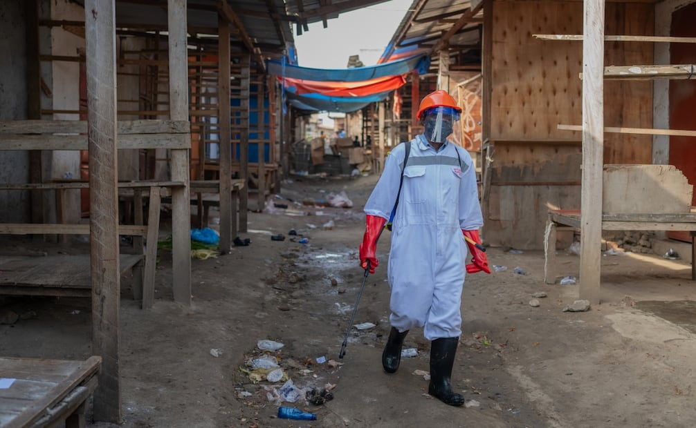 Un trabajador sanitario con equipo de protección desinfecta los puestos de un mercado de productos frescos en Bunia, República Democrática del Congo (23/05/2026). Foto: EFE
