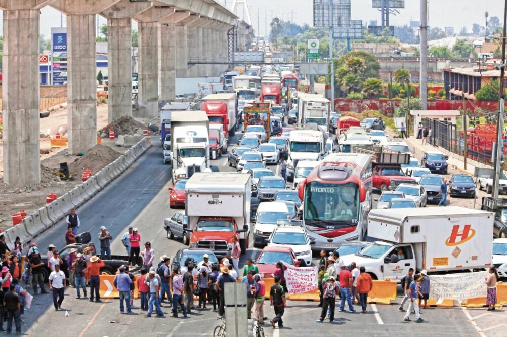 Desde las 12:45 de la tarde los pobladores de San Pedro Cholula colocaron vallas de plástico que tomaron de la obra del Tren Interurbano y atravesaron una camioneta para bloquear el paso. Foto: JORGE ALVARADO. EL UNIVERSAL