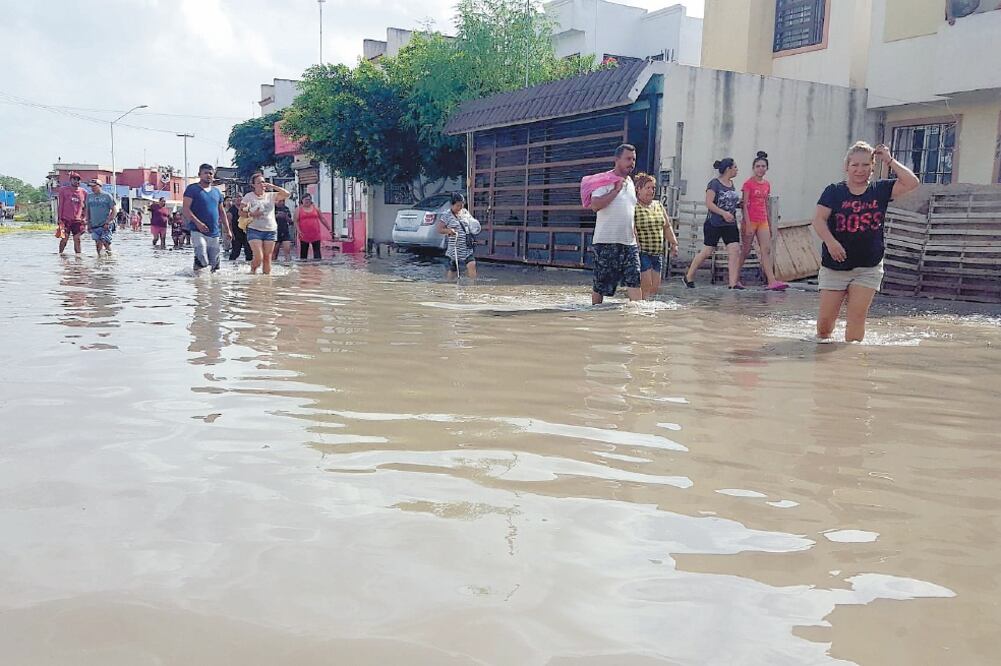 Con el agua hasta las rodillas, habitantes de la colonia Fraccionamiento Paseo de las Flores se dirigen hacia la autopista Reynosa-San Fernando para reclamar el drenaje pluvial prometido por las autoridades. Foto: SANDRA TOVAR. EL UNIVERSAL