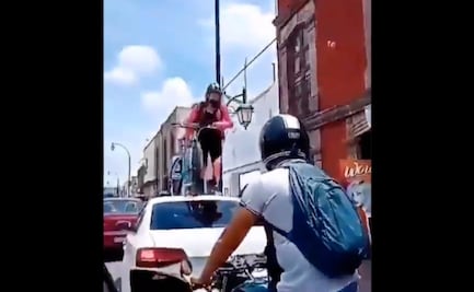Ciclista pasa por encima de automóvil que obstruía ciclovía en Querétaro