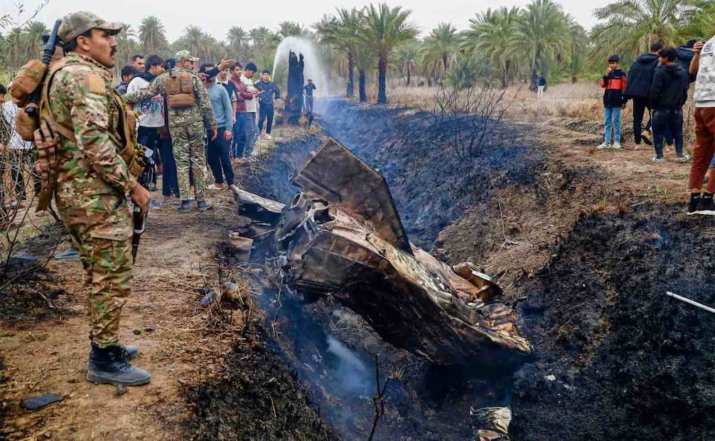 Fuerzas de seguridad iraquíes y residentes locales se reúnen en el lugar donde cayó un misil en una aldea rural en la zona de Siyahi. Foto: Karar Jabbar / AFP