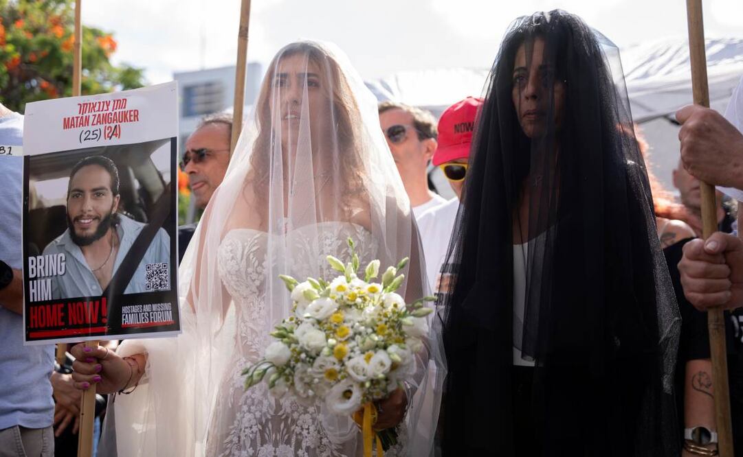 Con un cartel con la foto de su pareja, Matan Zangauker, quien se encuentra secuestrado por Hamas, Ilana Gritzewsky (izquierda) y su madre, Einav Zangauker, llegan a una ceremonia de boda simbólica en la plaza de los rehenes en Tel Aviv, Israel, el domingo 17 de agosto de 2025, durante una protesta para exigir la liberación inmediata de todos los rehenes y exigir al gobierno israelí que revoque su decisión de tomar el control de la ciudad de Gaza y otras zonas de la Franja de Gaza. Foto: AP
