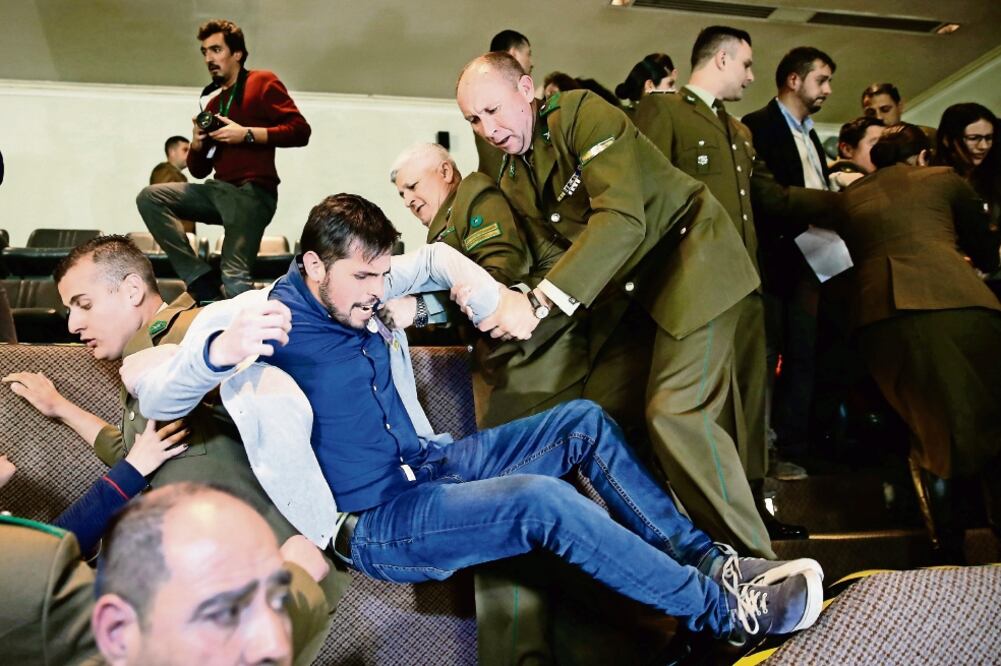 Policías detienen a un manifestante antiaborto al interior del Congreso chileno, la noche del martes, mientras senadores debatían el tema (RODRIGO GARRIDO. REUTERS)